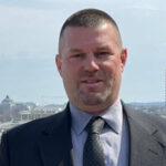 Man in suit with cityscape background.