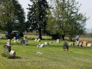 Cemetery with tombstones and people in background.