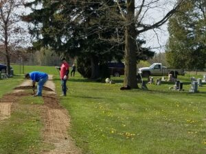 People working on a path in a cemetery.