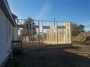 Wood framing structure under construction beside house