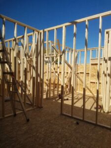 Wooden frame structure under construction with ladder.