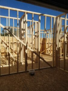 Wooden house frame construction under clear sky