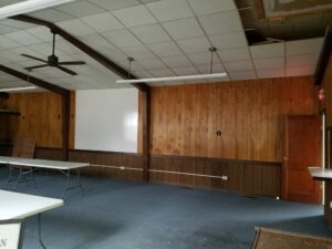 Empty room with wooden walls and tables.