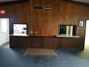 Wood-paneled room with two serving windows.