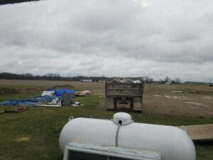 Rural construction site with materials on field.