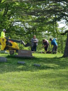 Workers digging near gravestones in cemetery