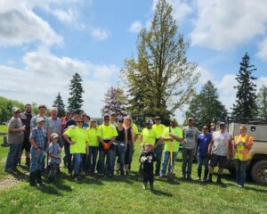 Group of volunteers at outdoor event with trees.